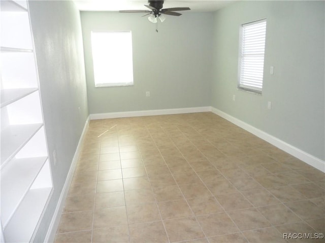 spare room featuring light tile patterned floors, plenty of natural light, baseboards, and a ceiling fan