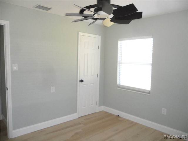 unfurnished room featuring visible vents, light wood-style flooring, and baseboards