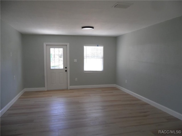 entrance foyer featuring light wood finished floors, visible vents, and baseboards