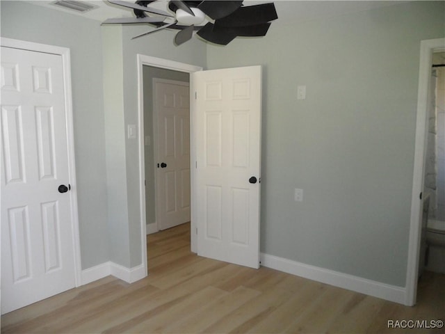 unfurnished bedroom featuring baseboards, visible vents, ceiling fan, and light wood finished floors