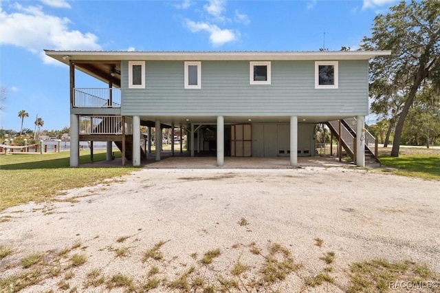 5500 S Cedar Mill Path, Homosassa, FL 34448 - raised beach house with stairway, a carport, dirt driveway, a ceiling fan, and a metal roof