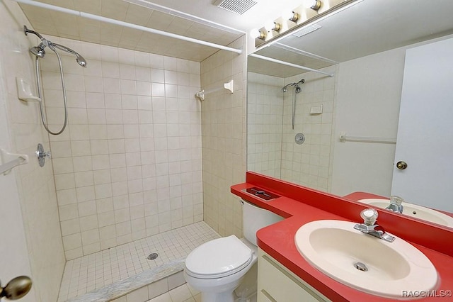 bathroom featuring tiled shower, vanity, and toilet