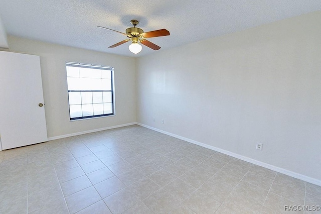 spare room with light tile patterned flooring, ceiling fan, and a textured ceiling