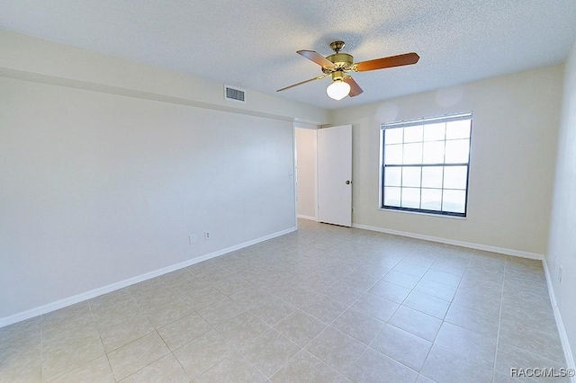 tiled spare room with ceiling fan and a textured ceiling