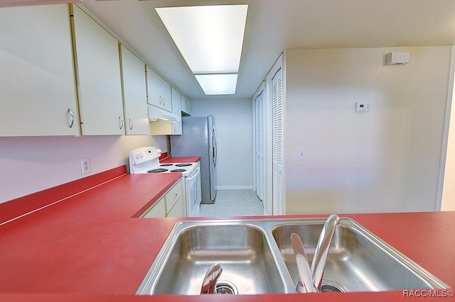 kitchen with sink, white electric stove, stainless steel refrigerator, and white cabinets