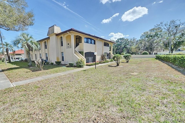 view of side of home with a yard, a chimney, and stucco siding