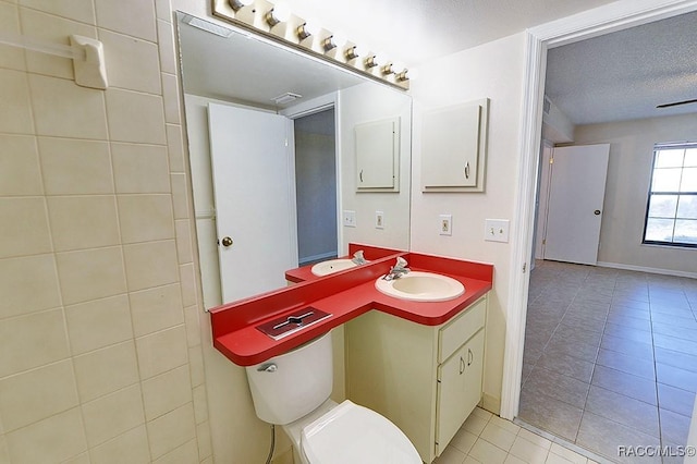 bathroom with vanity, a textured ceiling, tile patterned floors, and toilet