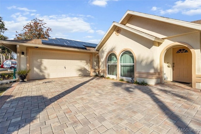 view of front of property featuring a garage and solar panels