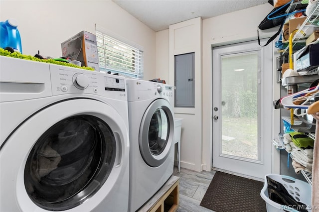 clothes washing area with a textured ceiling, electric panel, and washing machine and clothes dryer