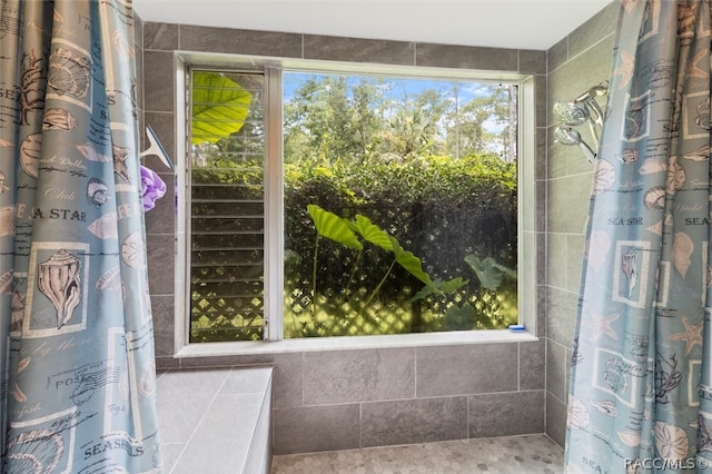 bathroom with plenty of natural light and tile walls