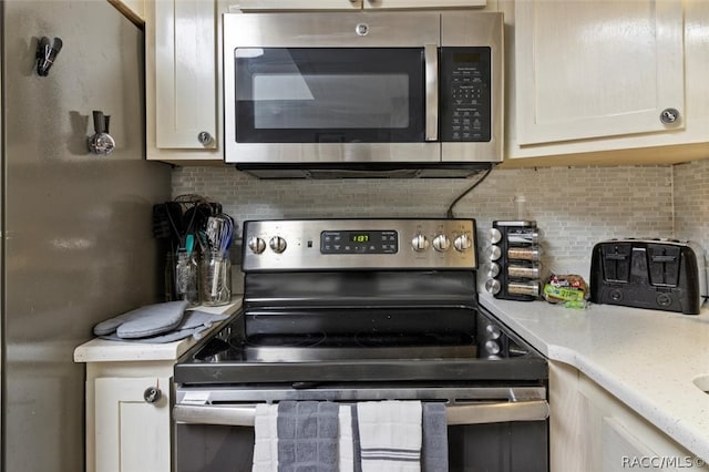 kitchen featuring stainless steel appliances, light stone counters, and tasteful backsplash