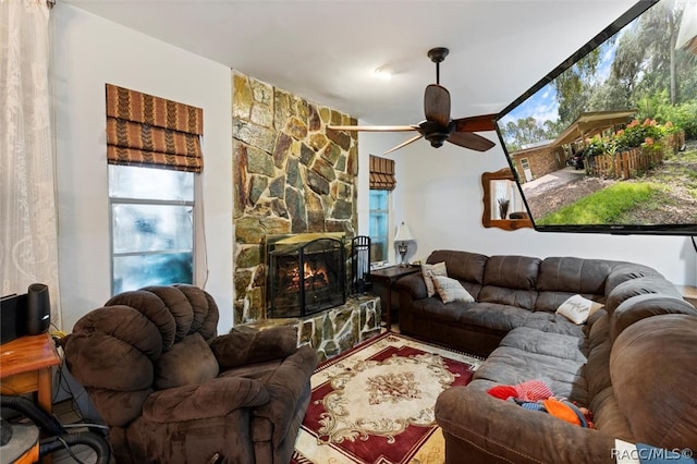 living room featuring ceiling fan and a fireplace