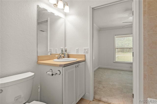 bathroom featuring toilet, ornamental molding, and vanity