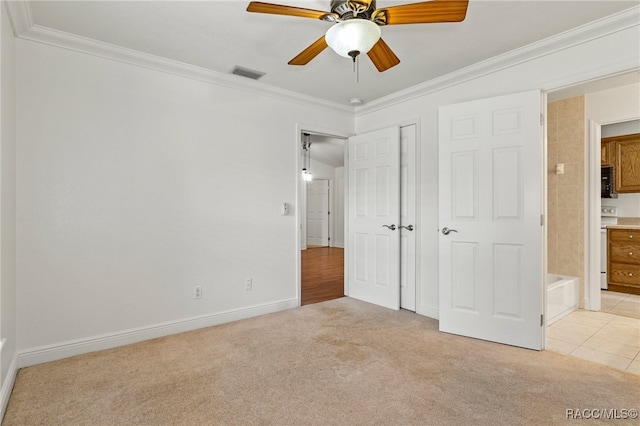 unfurnished bedroom with ceiling fan, ornamental molding, light colored carpet, and ensuite bath