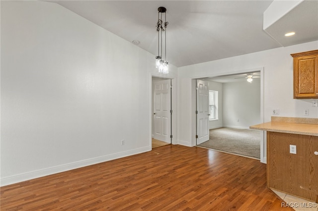 unfurnished dining area featuring lofted ceiling, ceiling fan, and dark hardwood / wood-style floors