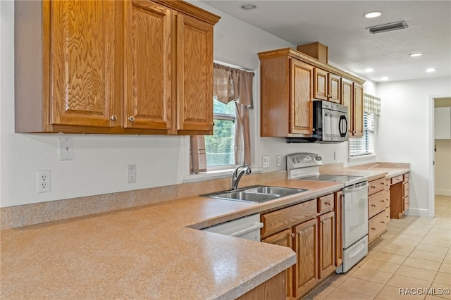 kitchen featuring light tile patterned floors, sink, and white appliances