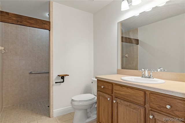 bathroom featuring tiled shower, tile patterned floors, vanity, and toilet