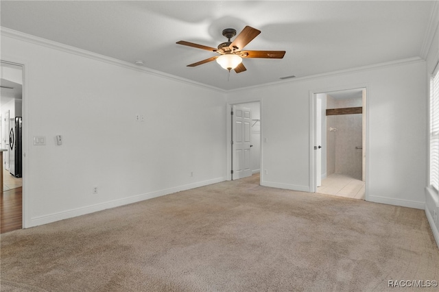 unfurnished bedroom featuring ceiling fan, ensuite bath, stainless steel refrigerator, ornamental molding, and light carpet