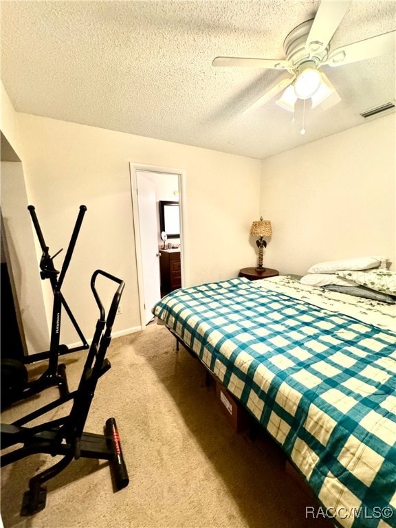 bedroom featuring a textured ceiling, carpet floors, ceiling fan, and visible vents