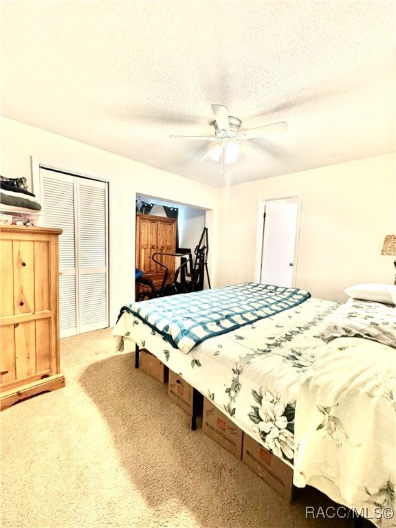 carpeted bedroom with a ceiling fan and a textured ceiling