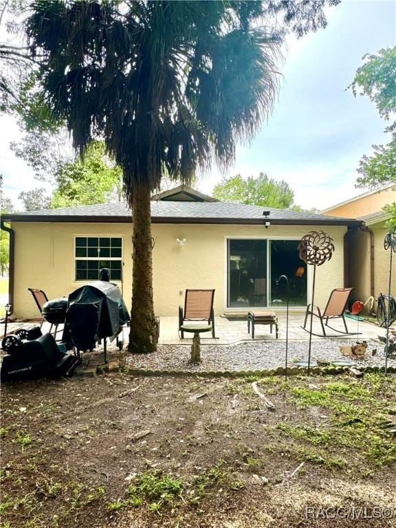 rear view of property with a patio area and stucco siding