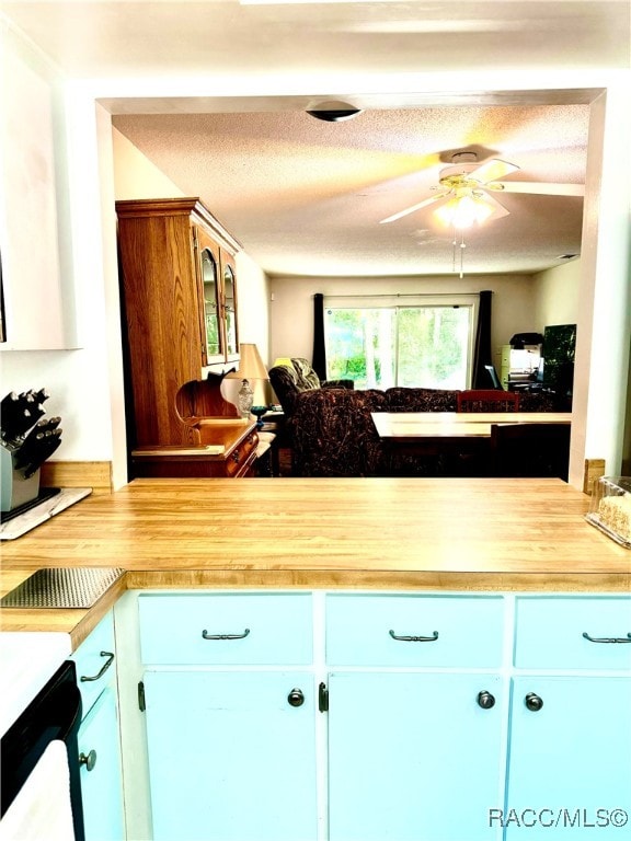 kitchen featuring dishwashing machine, a ceiling fan, light countertops, and a textured ceiling