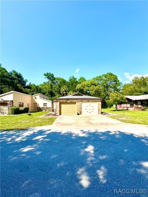 view of front facade with a front yard, a detached garage, and an outdoor structure