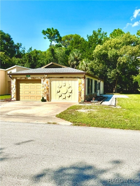 mid-century home with a garage, stone siding, and concrete driveway