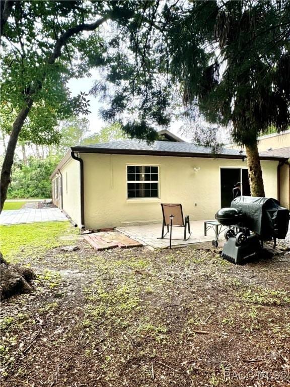 rear view of property with a patio area and stucco siding