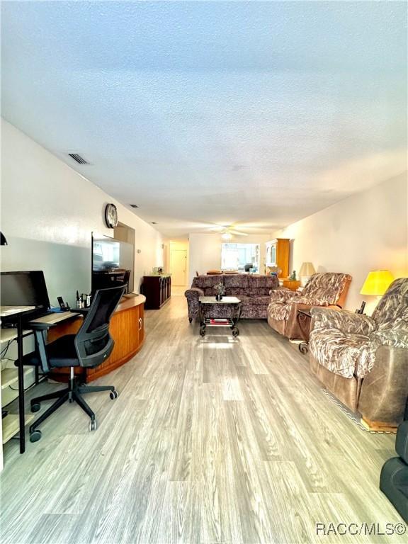 office area featuring a textured ceiling, wood finished floors, and visible vents