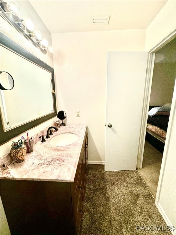 bathroom with visible vents, connected bathroom, vanity, and baseboards