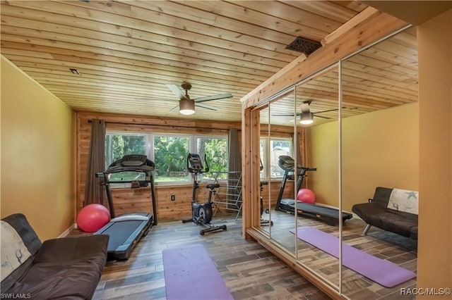 exercise room featuring dark hardwood / wood-style flooring, ceiling fan, wood walls, and wood ceiling