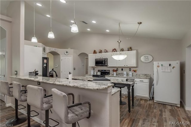 kitchen featuring dark hardwood / wood-style flooring, white refrigerator, decorative light fixtures, a breakfast bar area, and white cabinets