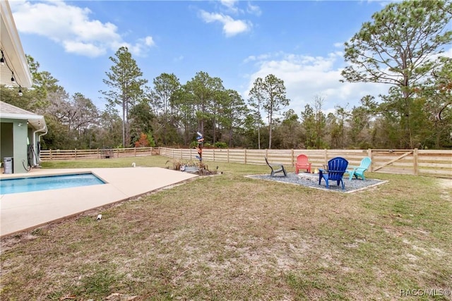 view of yard featuring a fenced in pool, a patio, and an outdoor fire pit