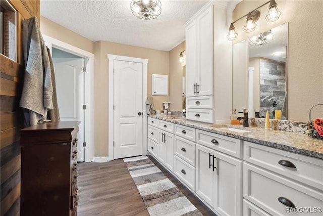 bathroom featuring hardwood / wood-style flooring, vanity, and a textured ceiling