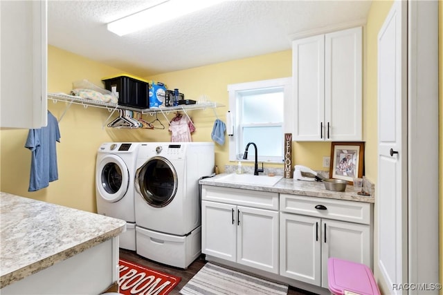 washroom featuring sink, cabinets, independent washer and dryer, and a textured ceiling