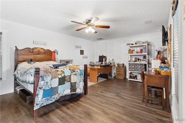 bedroom featuring dark wood-type flooring, a textured ceiling, and ceiling fan