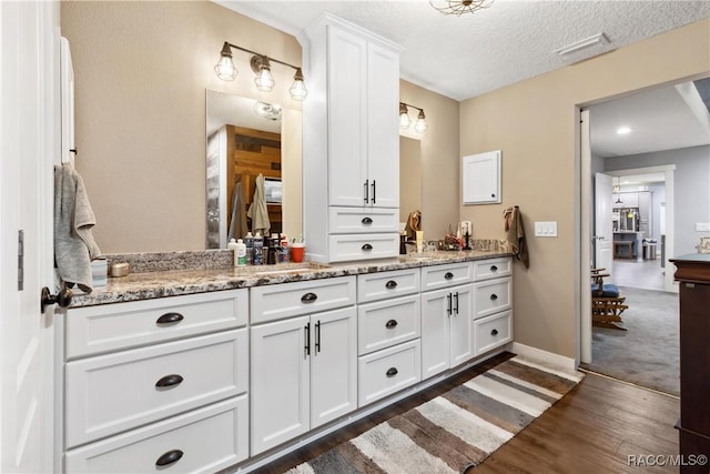 bathroom featuring vanity, wood-type flooring, and a textured ceiling