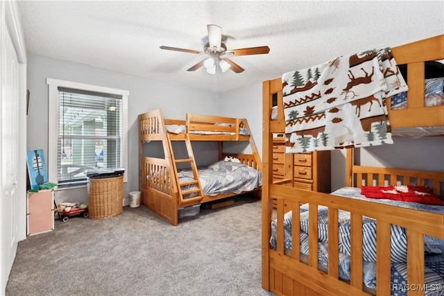 carpeted bedroom featuring ceiling fan and a textured ceiling