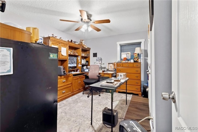 office area with ceiling fan and a textured ceiling