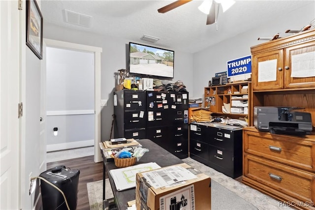 office area with a textured ceiling, dark hardwood / wood-style floors, and ceiling fan