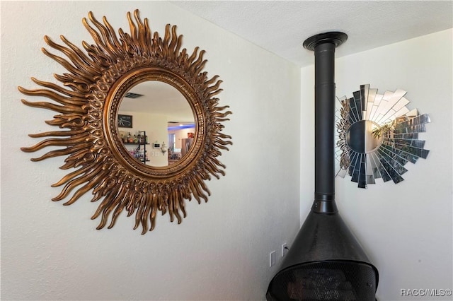 room details with a textured ceiling and a wood stove