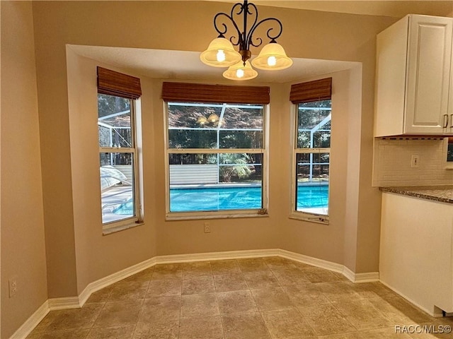 unfurnished dining area with an inviting chandelier