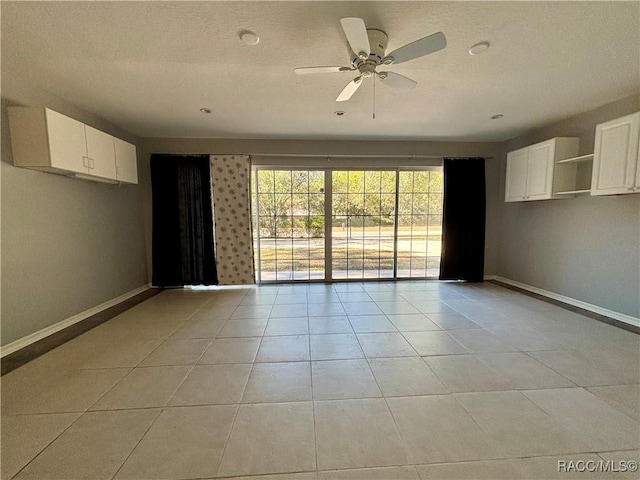 unfurnished room with ceiling fan and light tile patterned floors