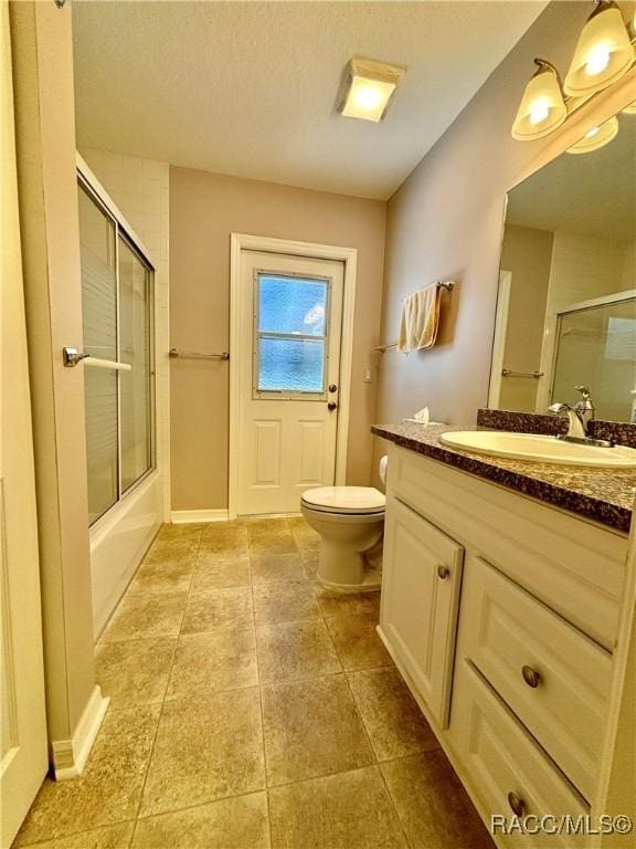 full bathroom with combined bath / shower with glass door, vanity, and toilet