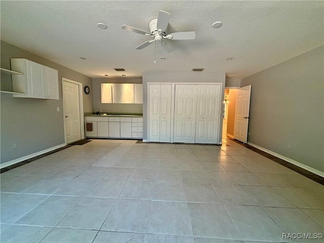 interior space with ceiling fan, a closet, light tile patterned floors, and sink