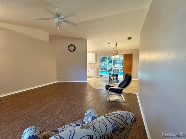 living room featuring ceiling fan with notable chandelier and wood-type flooring