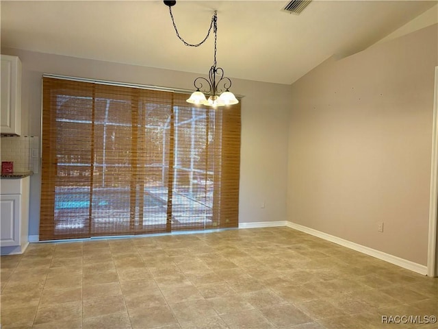 unfurnished dining area with a notable chandelier and lofted ceiling