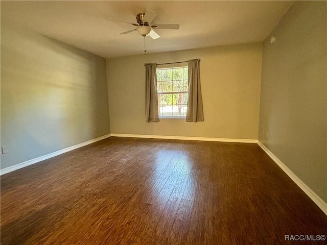 empty room featuring ceiling fan and dark wood-type flooring