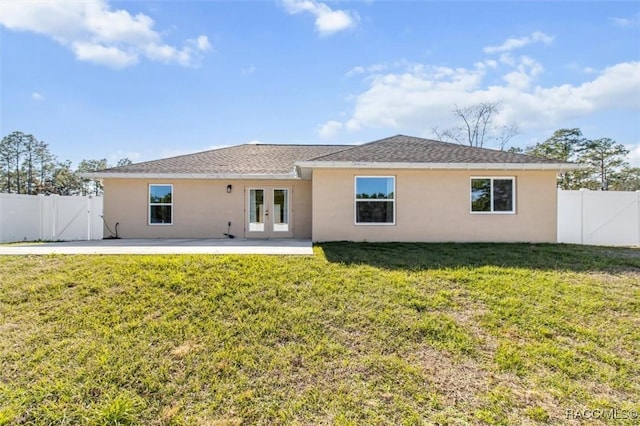 back of house with a patio and a lawn